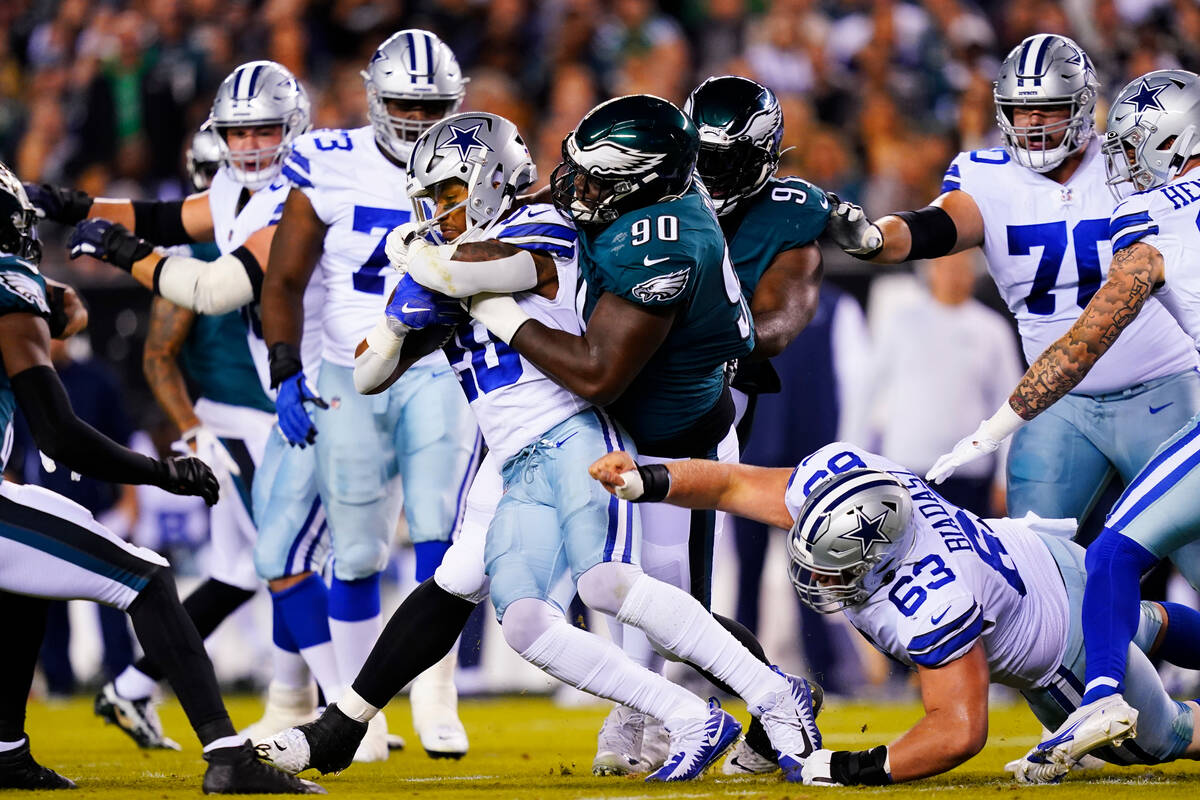 Dallas Cowboys' Tony Pollard is tackled by Philadelphia Eagles' Jordan Davis (90) during the fi ...