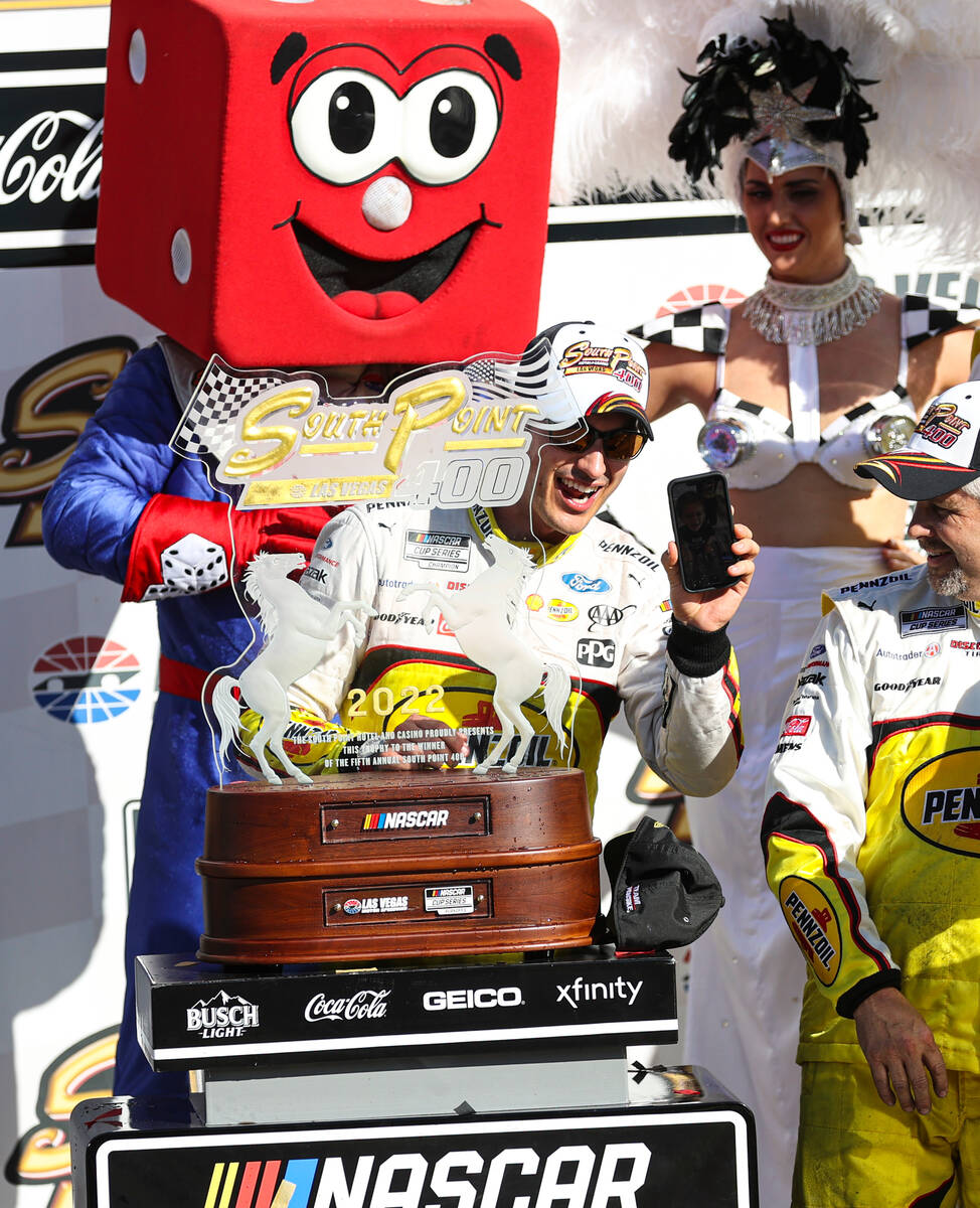NASCAR Cup Series driver Joey Logano holds his phone after winning the South Point 400 NASCAR C ...