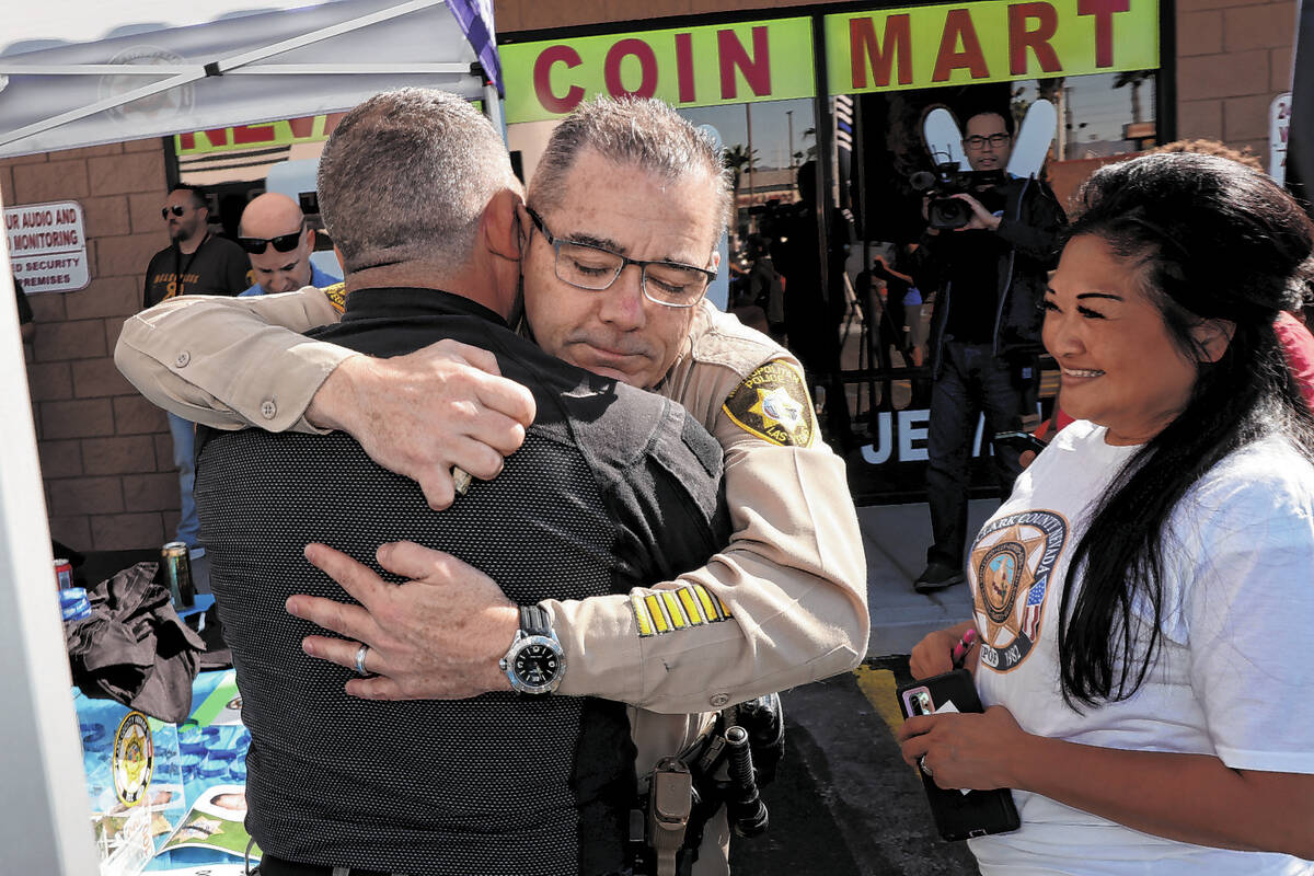 Las Vegas police Assistant Sheriff Andrew Walsh, facing, hugs, Las Vegas police officer Sal Mas ...