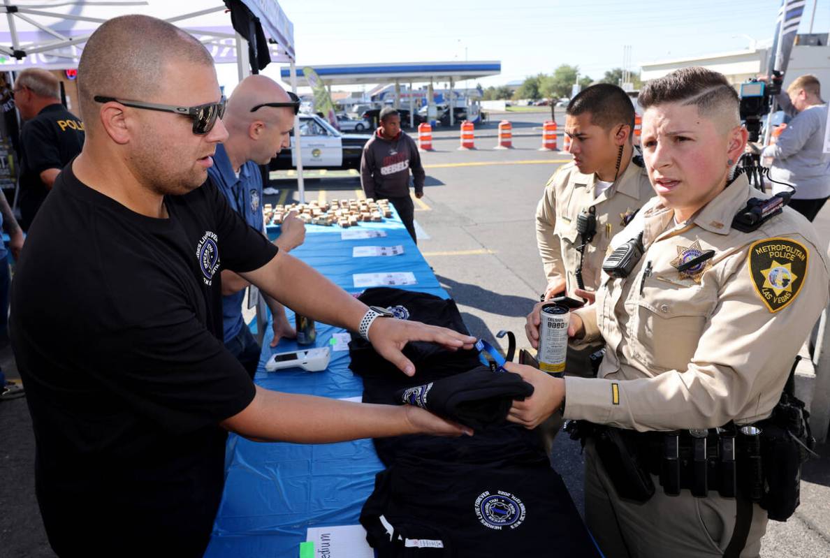 Las Vegas police officers, C. Madrid, right, and T. Nguyen buy T-shirts honoring fallen Las Ve ...