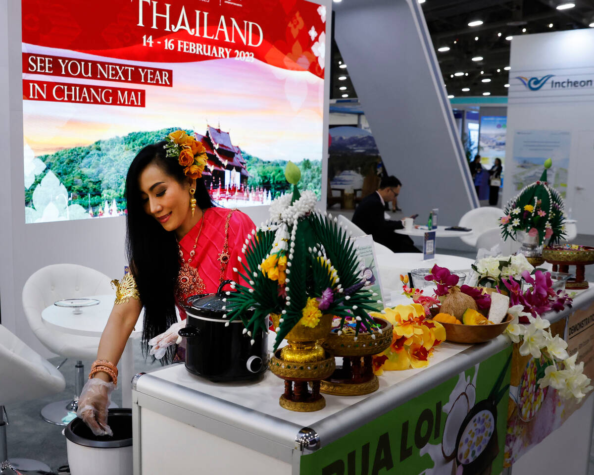 Ricky Nnpieeya prepares Bua loy, Thai coconut milk dessert, at Chiang Mai Airport booth during ...