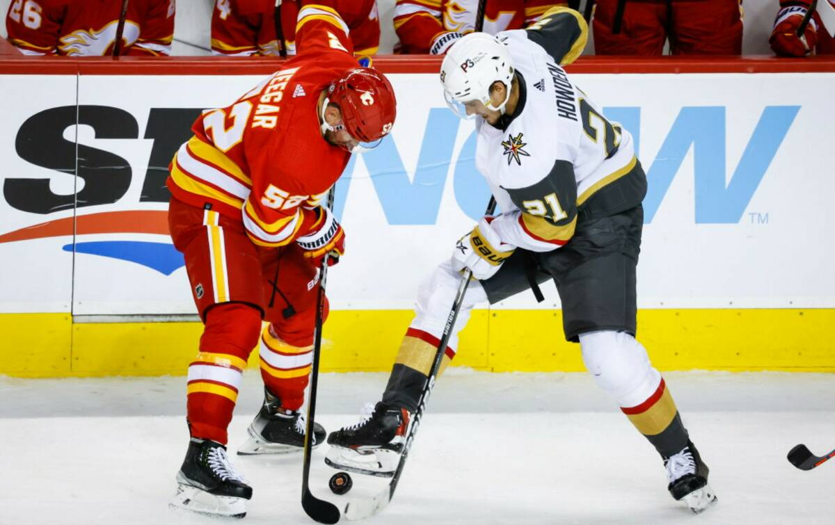 Vegas Golden Knights forward Brett Howden, right, and Calgary Flames defenseman MacKenzie Weega ...