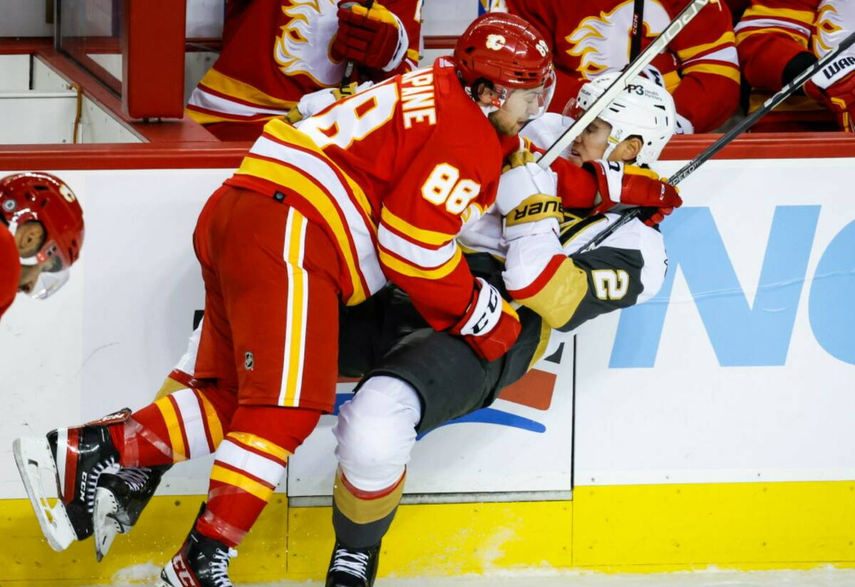 Vegas Golden Knights defenseman Zach Whitecloud, right, is checked by Calgary Flames forward An ...
