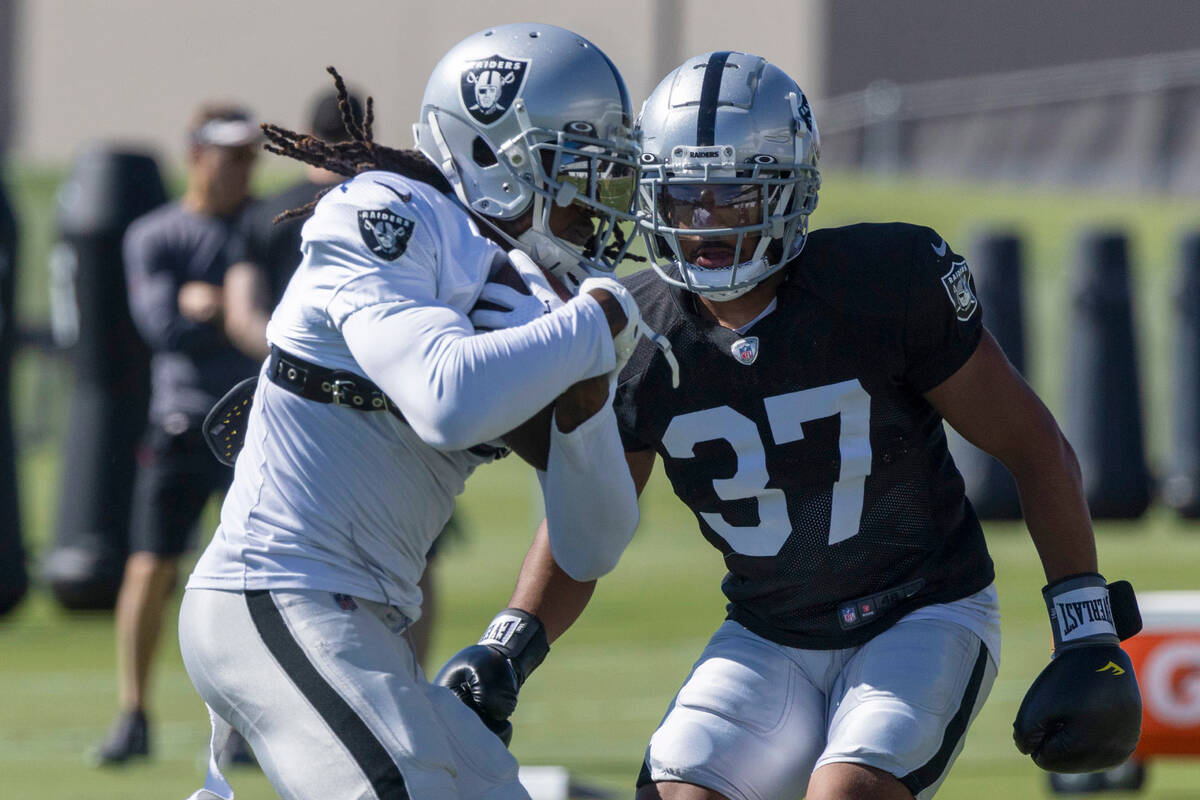 Raiders wide receiver Davante Adams (17) tries to hold on the football as cornerback Tyler Hall ...