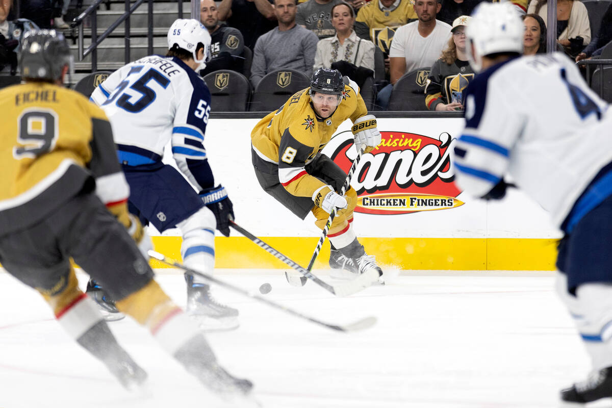 Golden Knights center Phil Kessel (8) looks to pass while center Jack Eichel (9) skates for the ...