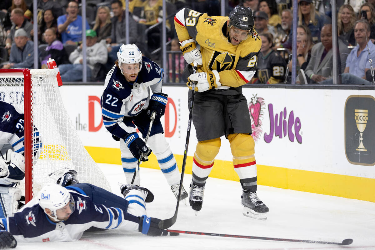 Jets defenseman Dylan DeMelo (2) dives to defend while Golden Knights defenseman Alec Martinez ...