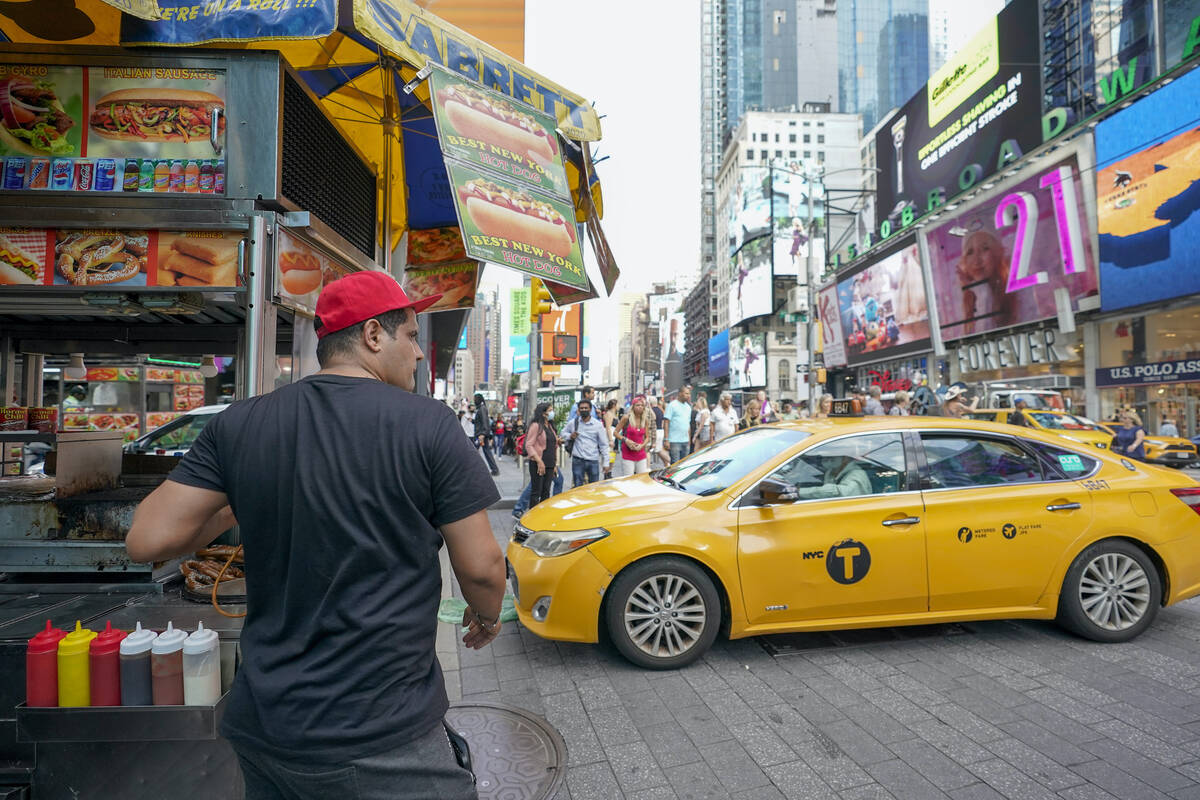 Youssef Mohamed moves his hot dog cart into his spot on 45th Street in New York's Times Square ...