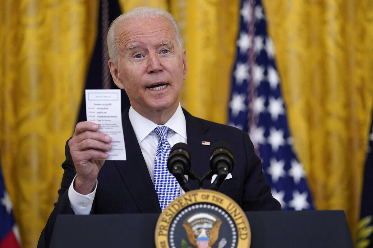 FILE - President Joe Biden holds a note card that has the number of COVID-19-related American d ...