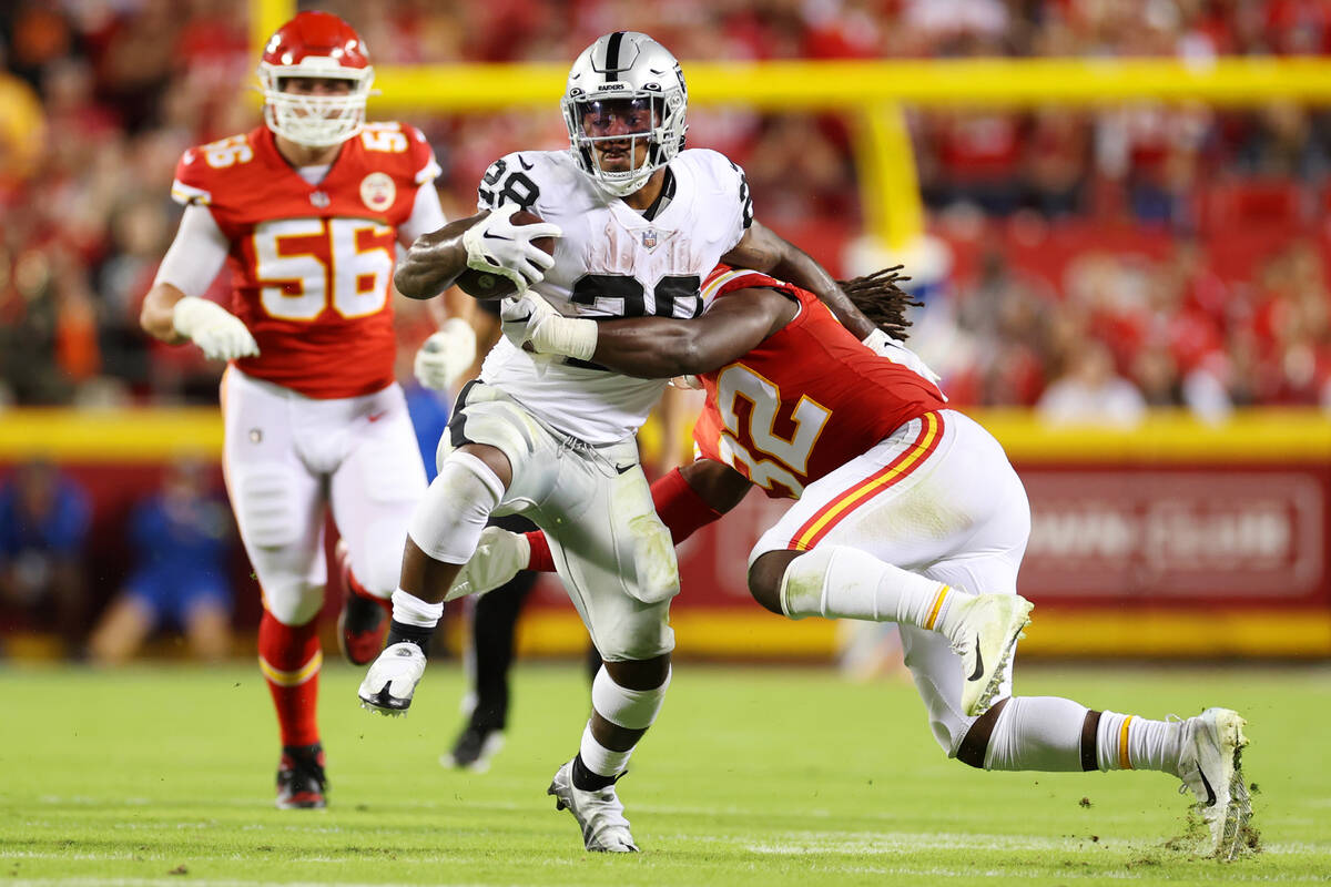 Kansas City Chiefs linebacker Nick Bolton (32) tackles Raiders running back Josh Jacobs (28) af ...