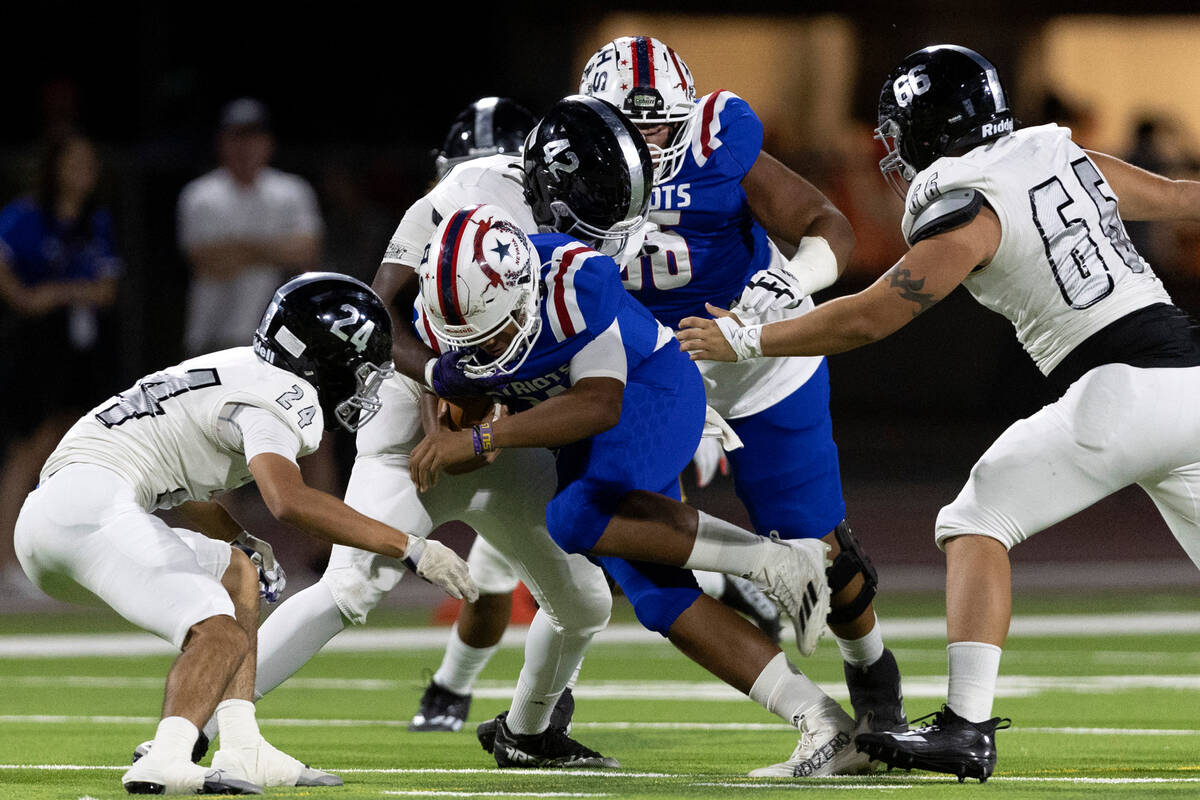 Liberty’s Tyrese Smith (11) attempts to run through Desert Pines’ defense includi ...