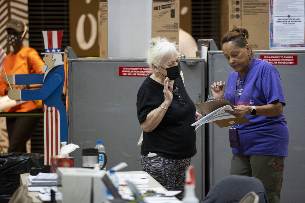 Poll worker Nadine Singleton, right, assists a voter at the polling place inside of the Galleri ...