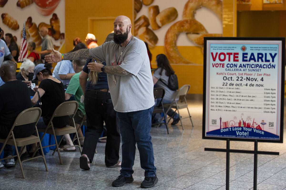 Poll worker Phil Hallond directs people at the polling place inside of the Galleria at Sunset s ...