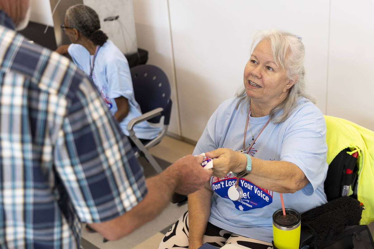 Poll worker Terry Kilne hands out an I voted sticker at the polling place inside of the East La ...