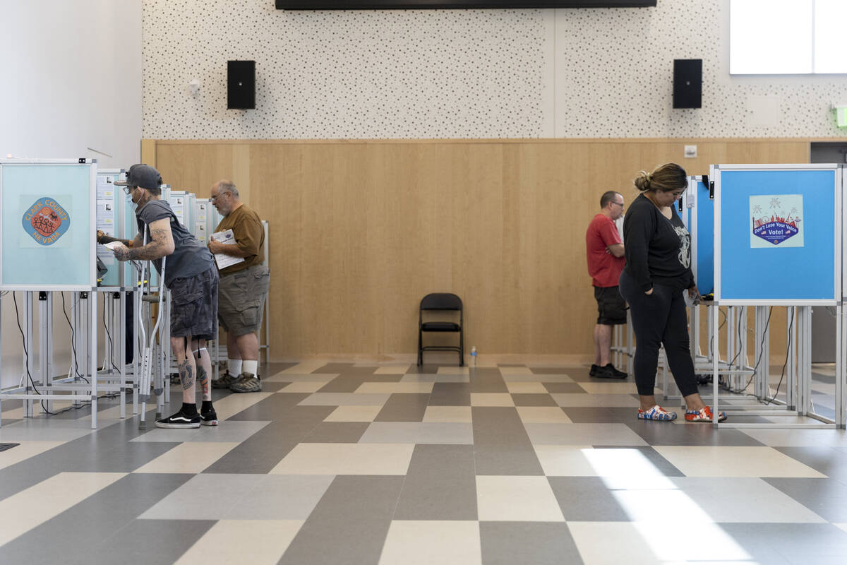 People cast their votes at the polling place inside of the East Las Vegas Library in Las Vegas, ...