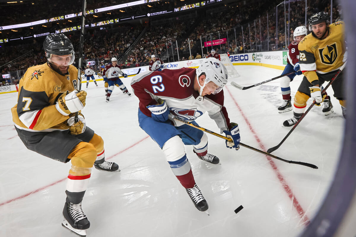 Colorado Avalanche center Nathan MacKinnon (29) moves the puck under pressure from Vegas Golden ...