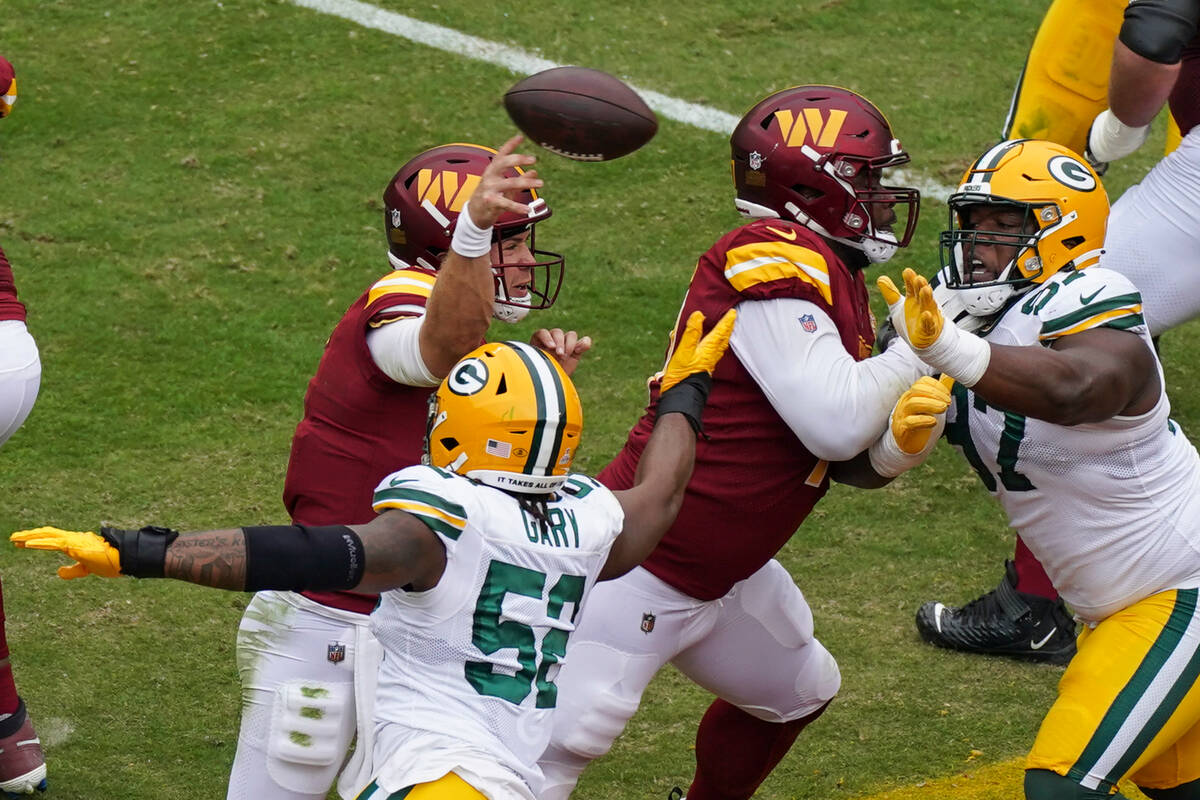 Washington Commanders quarterback Taylor Heinicke (4) throws under pressure from Green Bay Pack ...