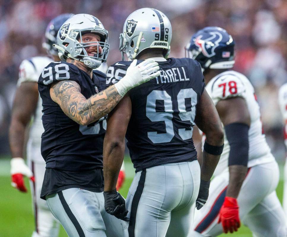 Raiders defensive end Maxx Crosby (98) congratulates teammate Raiders defensive end Clelin Ferr ...