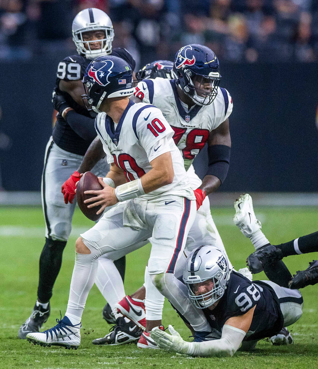 Houston Texans quarterback Davis Mills (10) gets stopped in the pocket by Raiders defensive end ...