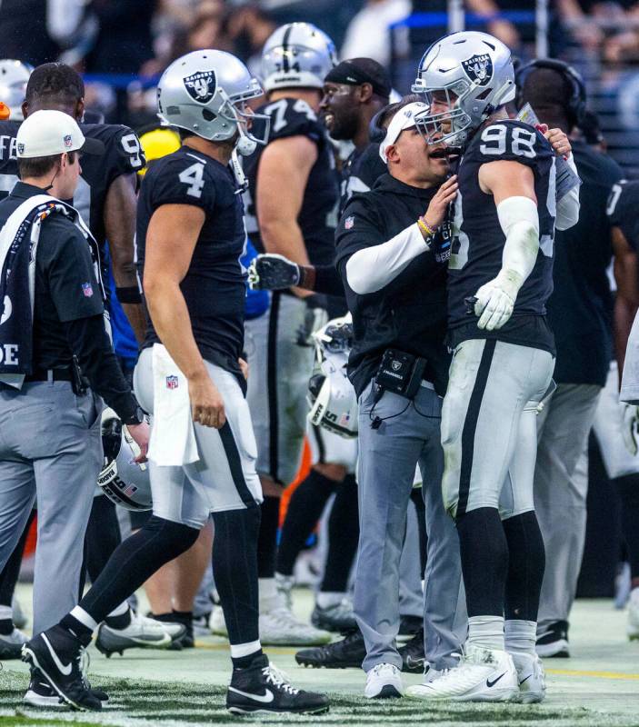 Raiders Head Coach Josh McDaniels talks with defensive end Maxx Crosby (98) on the sidelines du ...