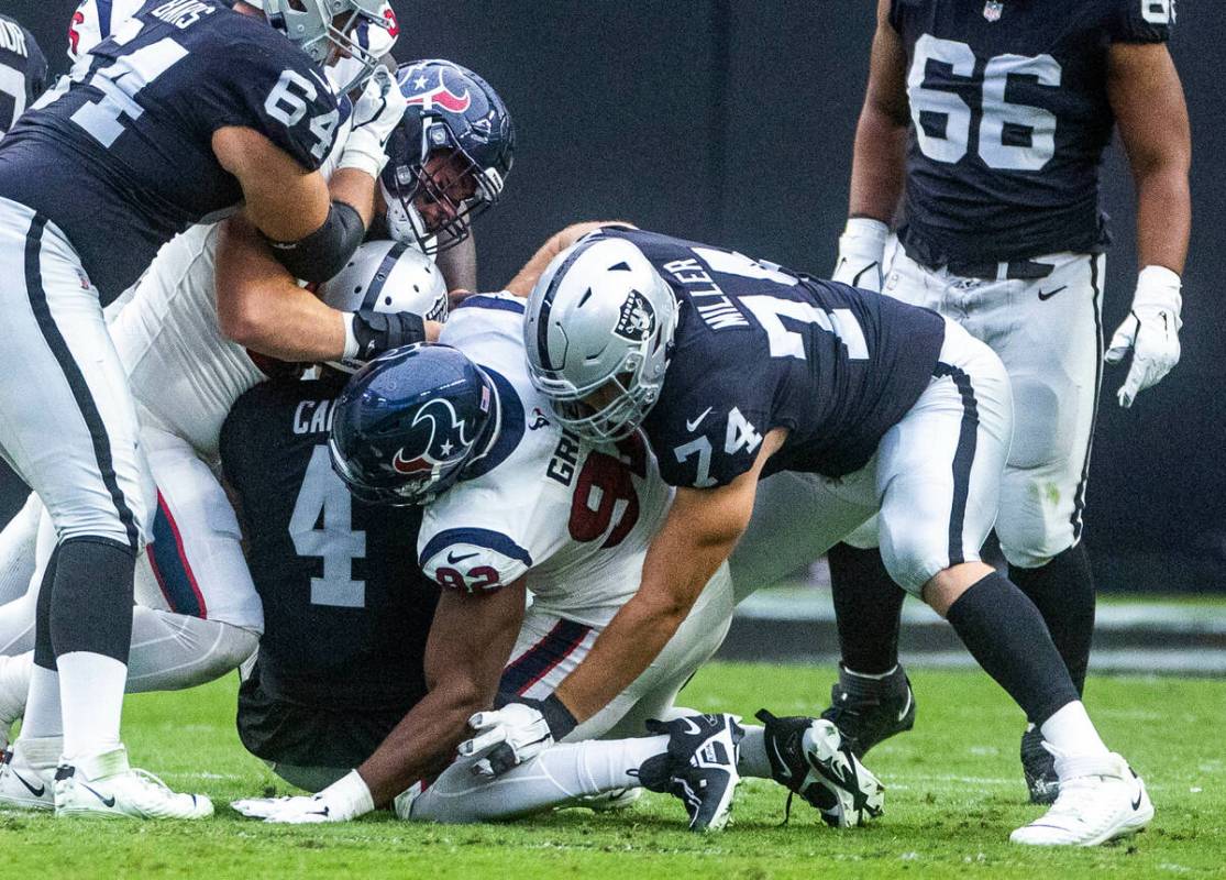 Raiders quarterback Derek Carr (4) is sacked by Houston Texans defensive end Rasheem Green (92) ...