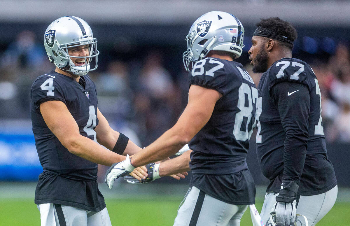 Raiders quarterback Derek Carr (4) congratulates tight end Foster Moreau (87) after they score ...