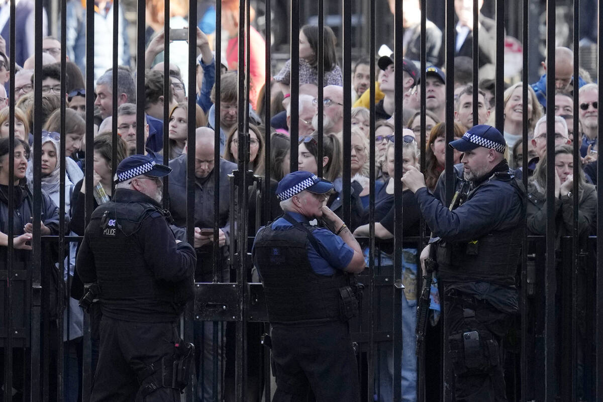 Members of the public look through the gates at Downing Street in London, Monday, Oct. 24, 2022 ...