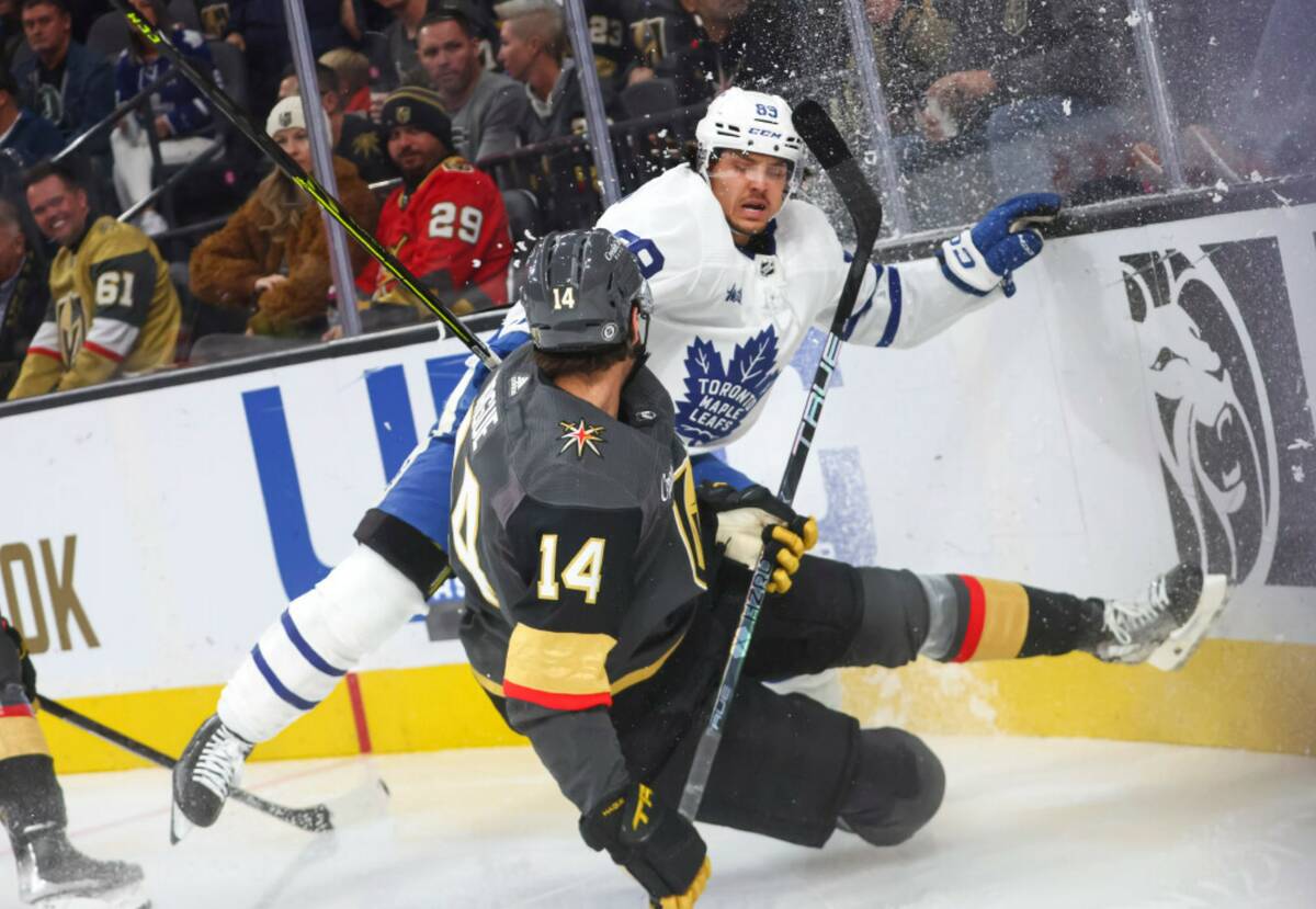 Golden Knights defenseman Nicolas Hague (14) slips to the ice at the boards in front of Toronto ...