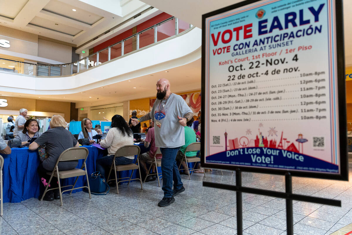 Poll worker Phil Hallond directs people at the polling place inside of the Galleria At Sunset s ...