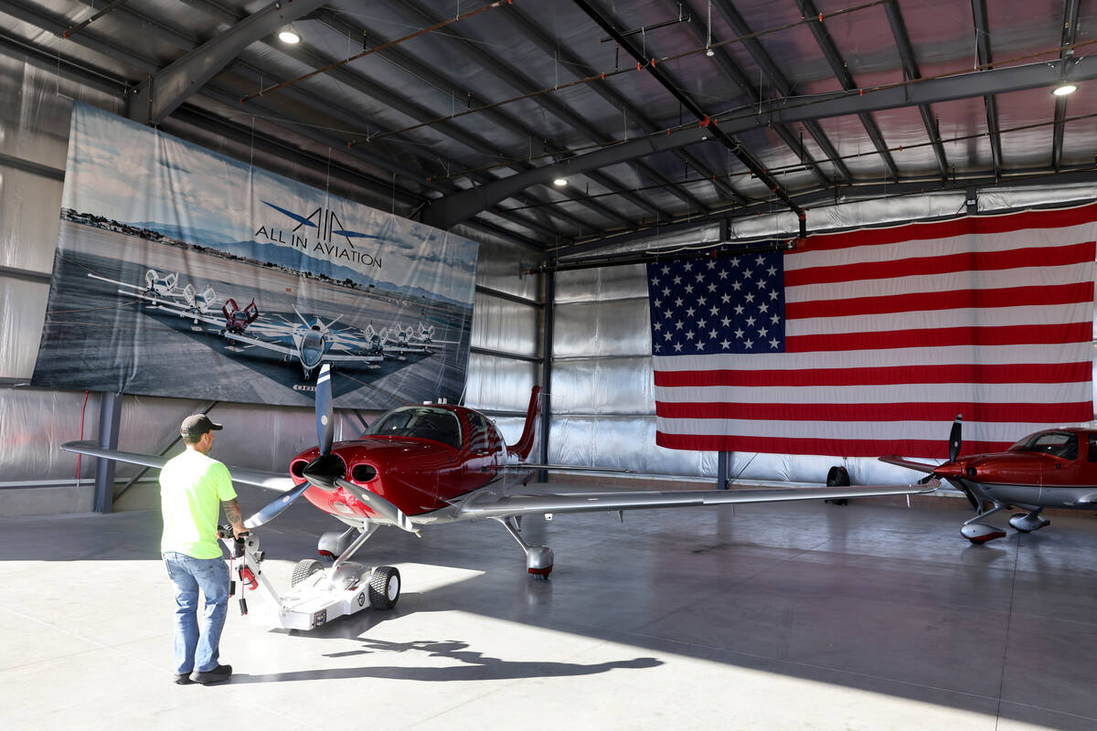 Aaron Rees, flight line manager at All In Aviation flight school, moves a plane for a student f ...