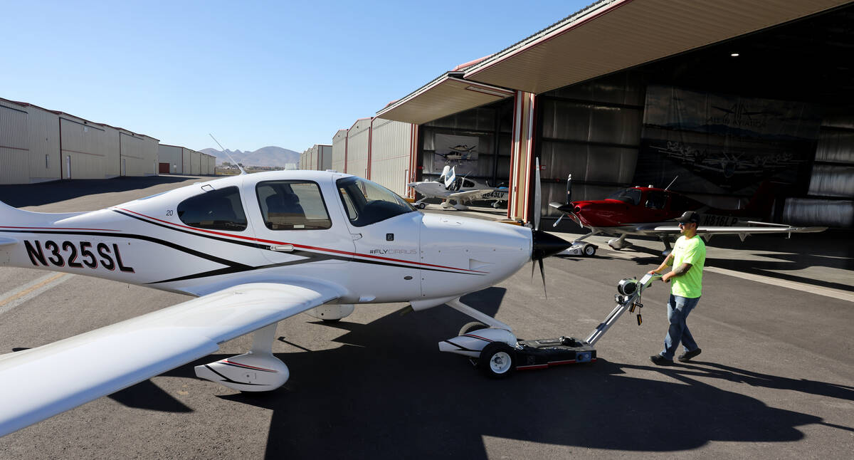 Aaron Rees, flight line manager at All In Aviation flight school, moves a plane for a student f ...