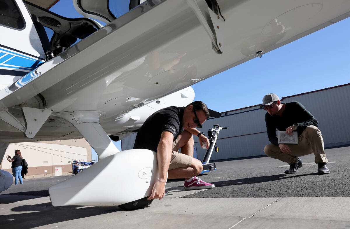Certified Flight Instructor Aaron Adams, left, prepares for a student flight with Chris Bless o ...