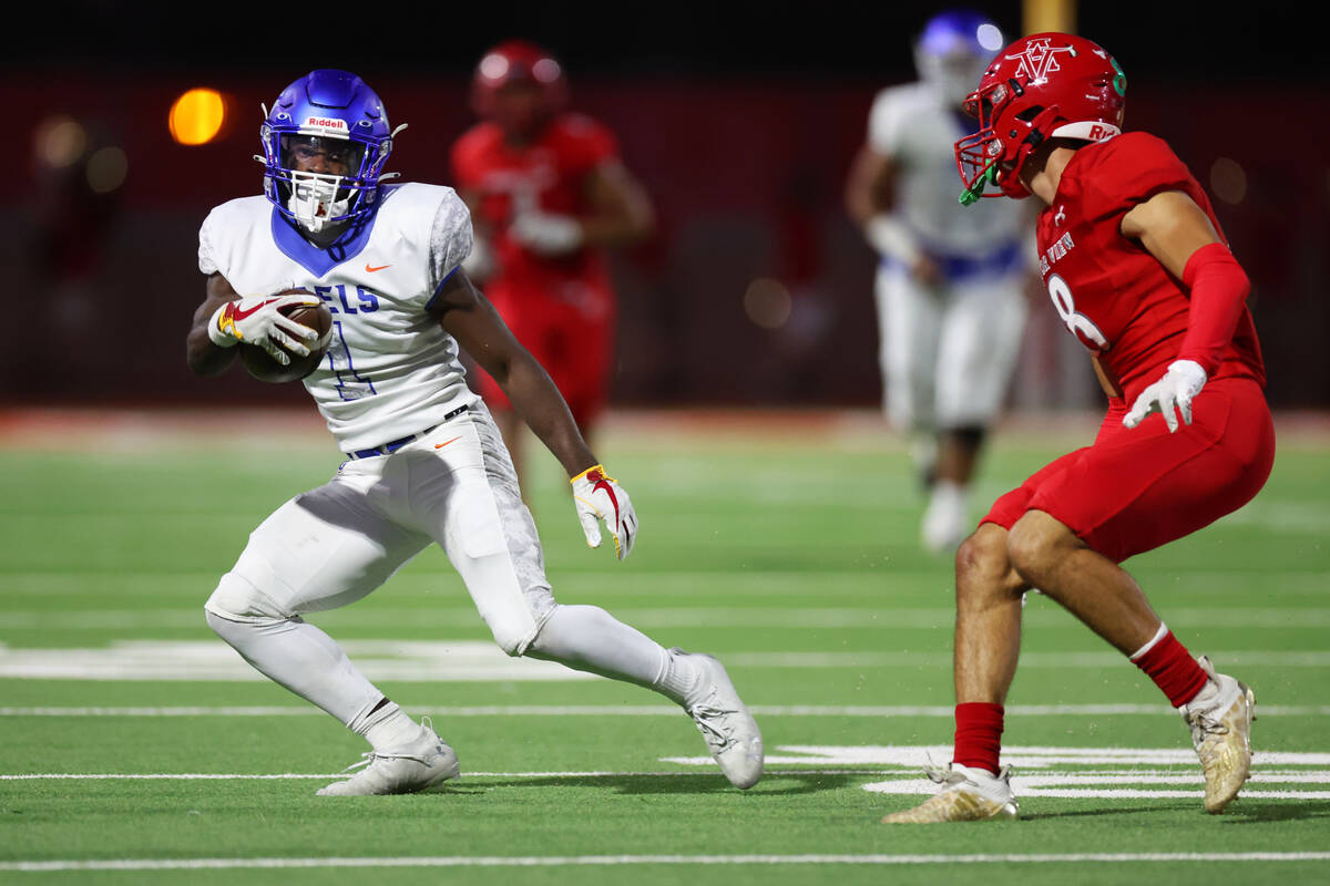 Bishop Gorman's Zachariah Branch (1) runs the ball under pressure from Arbor View's Kade DeSant ...