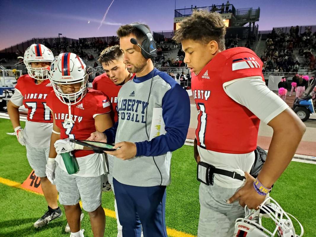 Liberty offensive coordinator Mark Bly goes over the game plan during the Patriots' playoff gam ...