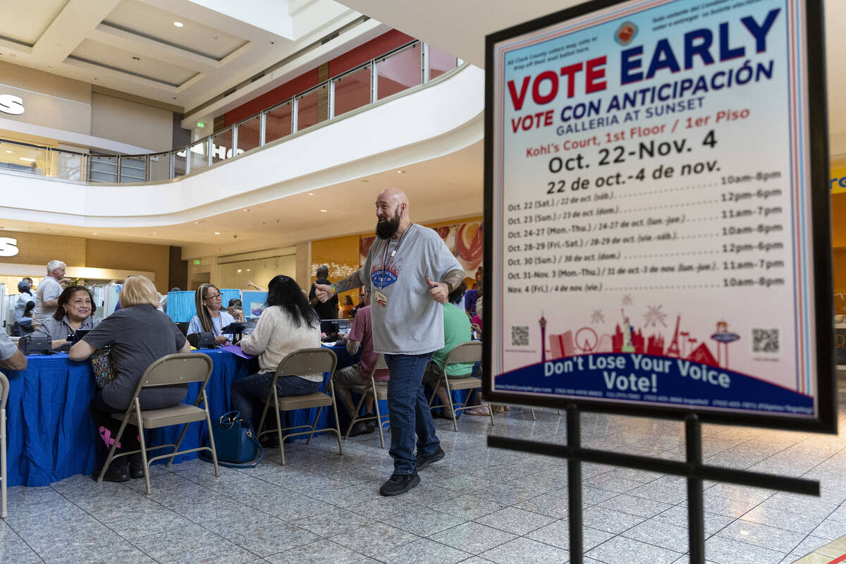 Poll worker Phil Hallond directs people at the polling place inside of the Galleria At Sunset s ...