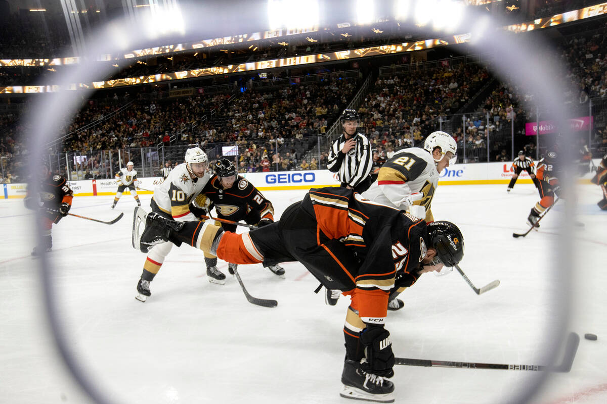 Ducks defenseman Dmitry Kulikov (29) and Golden Knights center Brett Howden (21) dive for the p ...