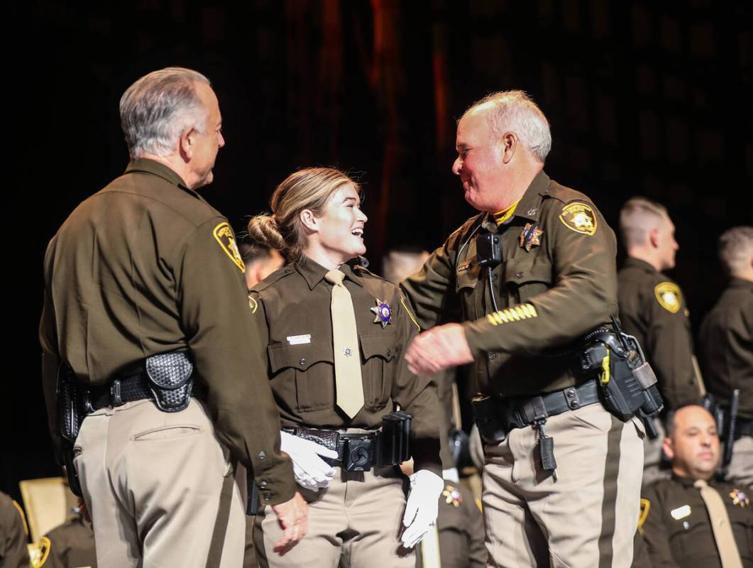 Officer Stephen Kircher, right, goes in to hug his daughter and academy graduate Kirsten Kirche ...