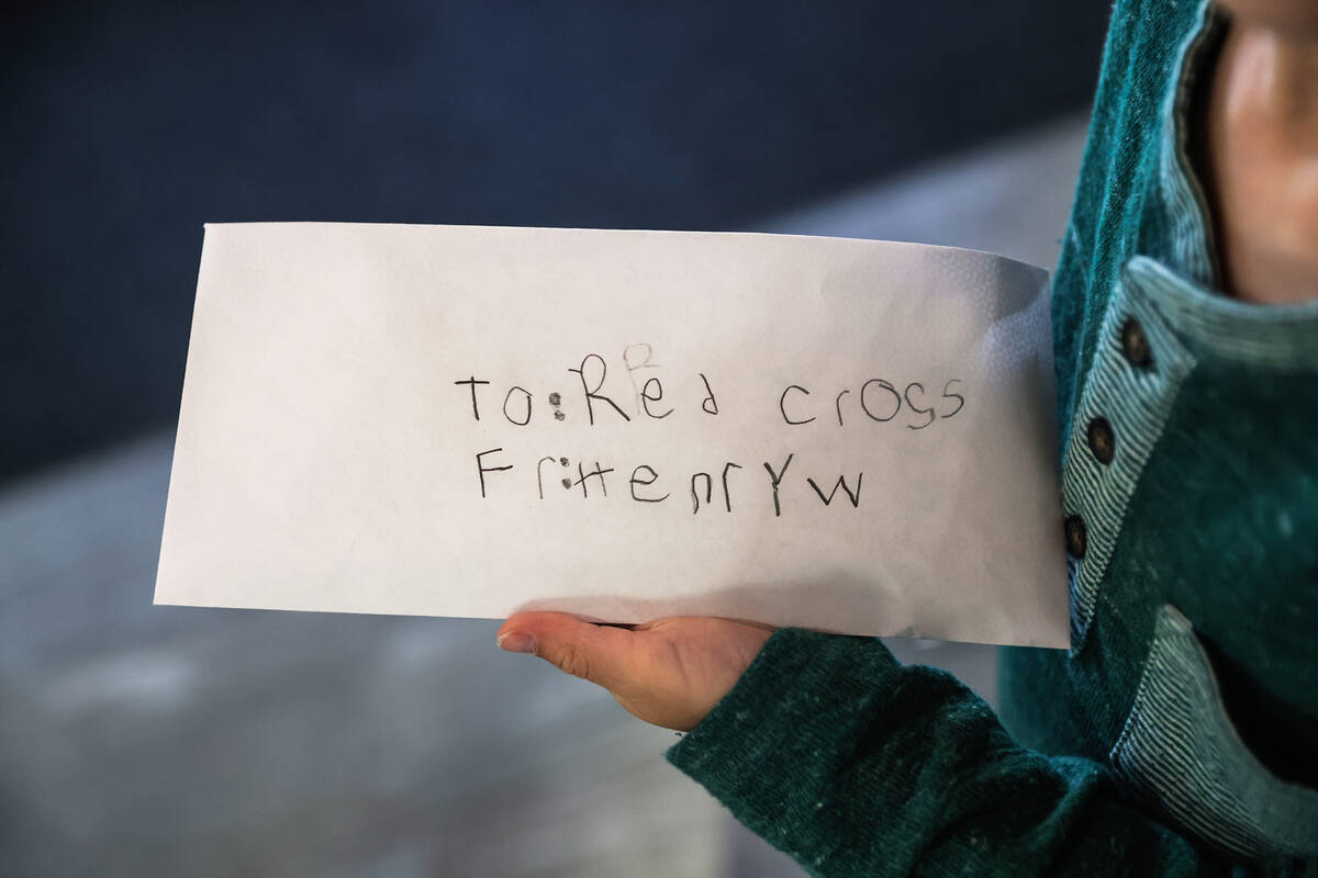 Henry Williams, 6, holds the envelope of $800 that he earned for the American Red Cross running ...