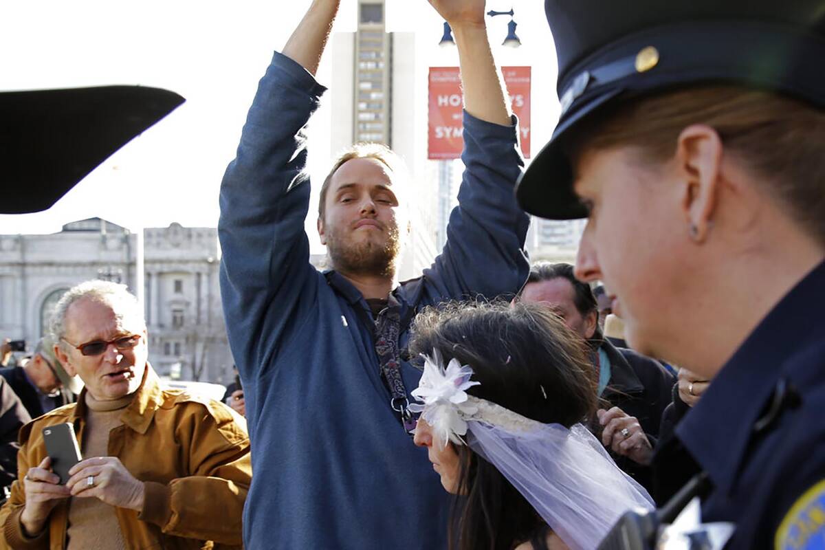 David DePape, center, shoots video of Gypsy Taub being led away by police after her wedding out ...