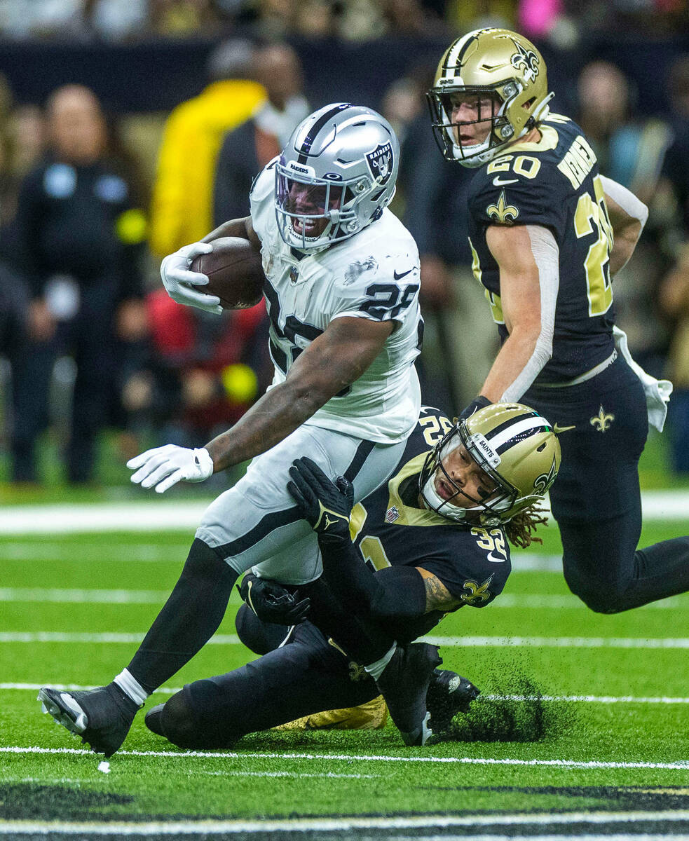 Raiders running back Josh Jacobs (28) is tackled from behind by New Orleans Saints safety Tyran ...