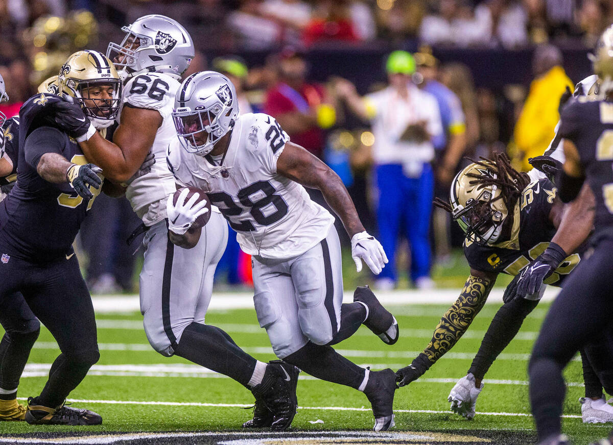 Raiders running back Josh Jacobs (28) breaks through the defensive line as New Orleans Saints l ...