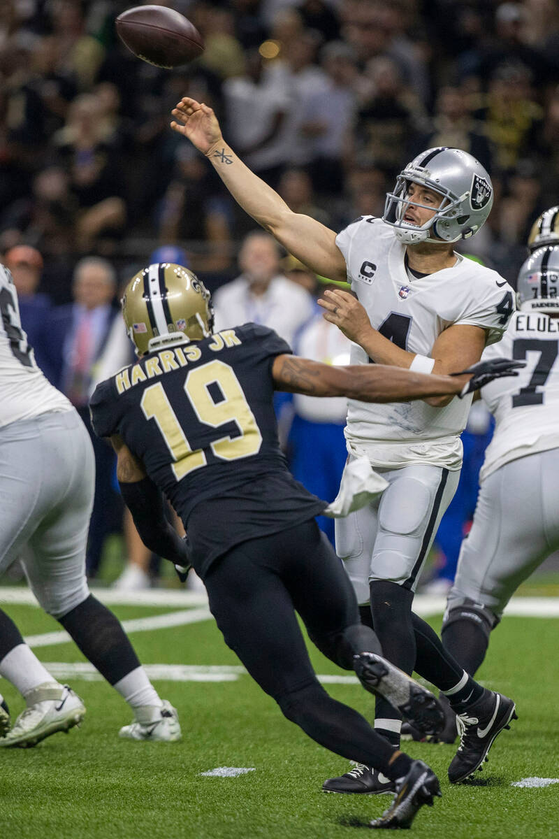 Raiders quarterback Derek Carr (4) throws under pressure from New Orleans Saints safety Chris H ...