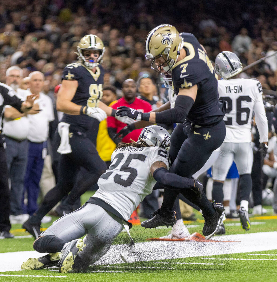 Raiders safety Tre'von Moehrig (25) tackles New Orleans Saints tight end Taysom Hill (7) during ...