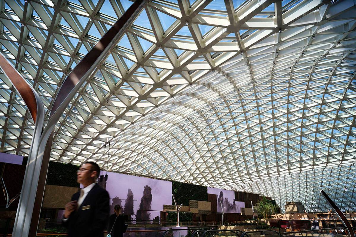 A man walks against the atrium roof at MGM Cotai Resort in Macau Tuesday, Feb. 13, 2018. (AP Ph ...