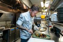 Main St. Provisions chef Patrick Munster prepares a double cut bone-in ribeye on Thursday, Oct. ...