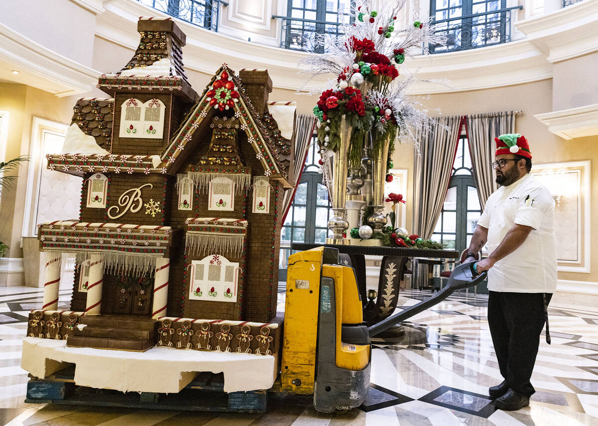 Omar Mejia-Orta, assistant pastry chef, wheels the gingerbread house through the casino to be d ...