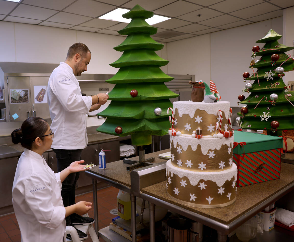 Chef director Philippe Angibeau works on a gingerbread house display with Sous Chef Chocolatier ...