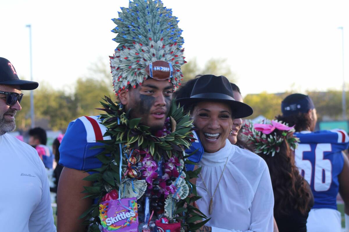 Liberty's Tiafau Gora walks with his family on Senior Night at Liberty High School on Friday, O ...