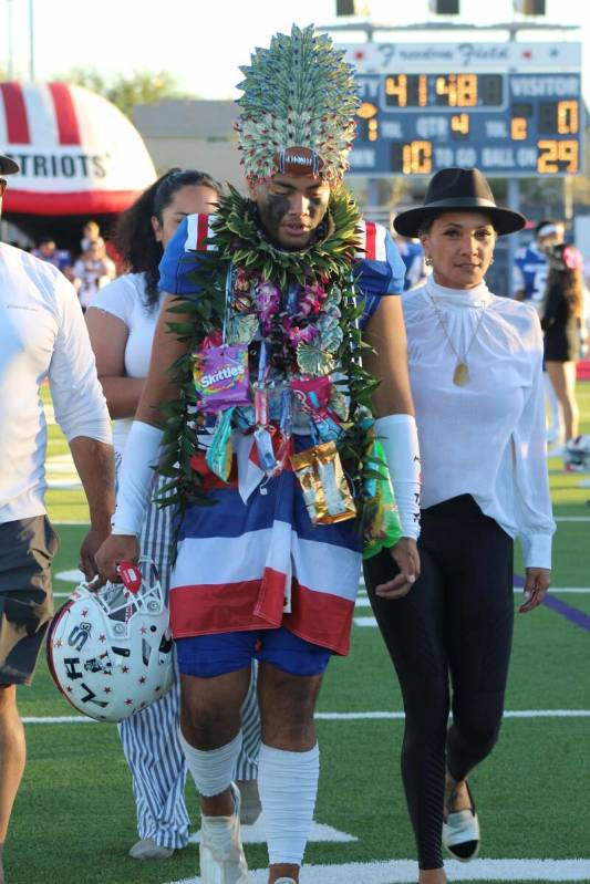 Liberty's Tiafau Gora walks with his family on Senior Night at Liberty High School on Friday, O ...