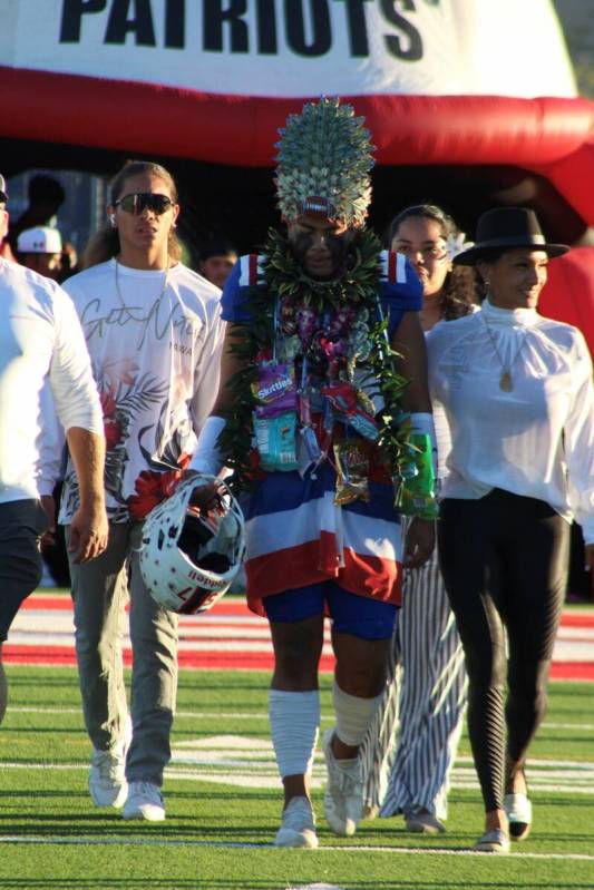 Liberty's Tiafau Gora walks with his family on Senior Night at Liberty High School on Friday, O ...