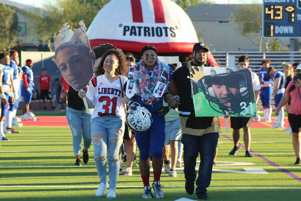 Liberty's Isiah Bloecher walks with his family on Senior Night at Liberty High School on Friday ...